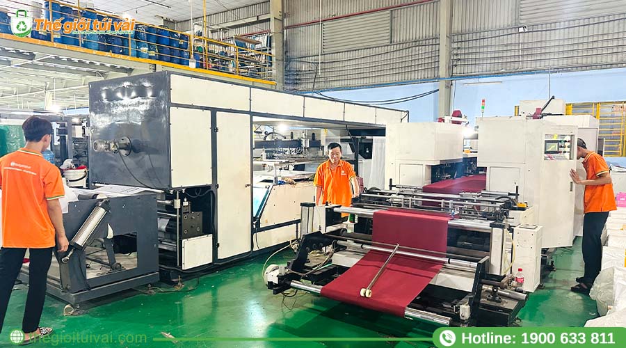Công nhân vận hành dây chuyền sản xuất túi vải không dệt tại nhà máy