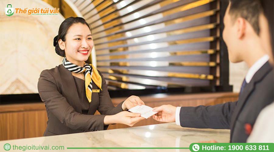 Nhân viên resort mỉm cười trao khăn lạnh cho khách ngay tại sảnh Nhân viên resort mỉm cười trao khăn lạnh cho khách ngay tại sảnh